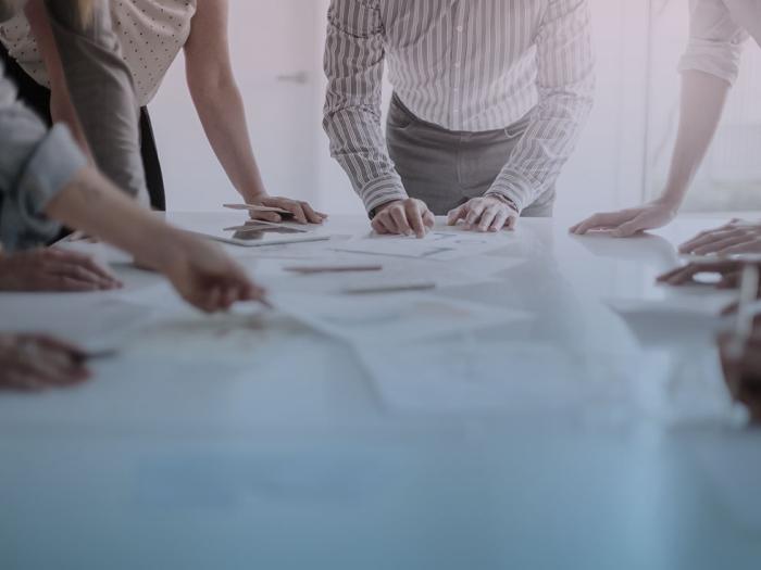 A group of people huddled around a table looking at plans