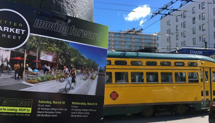 poster on street pole and a trolley going down Market street